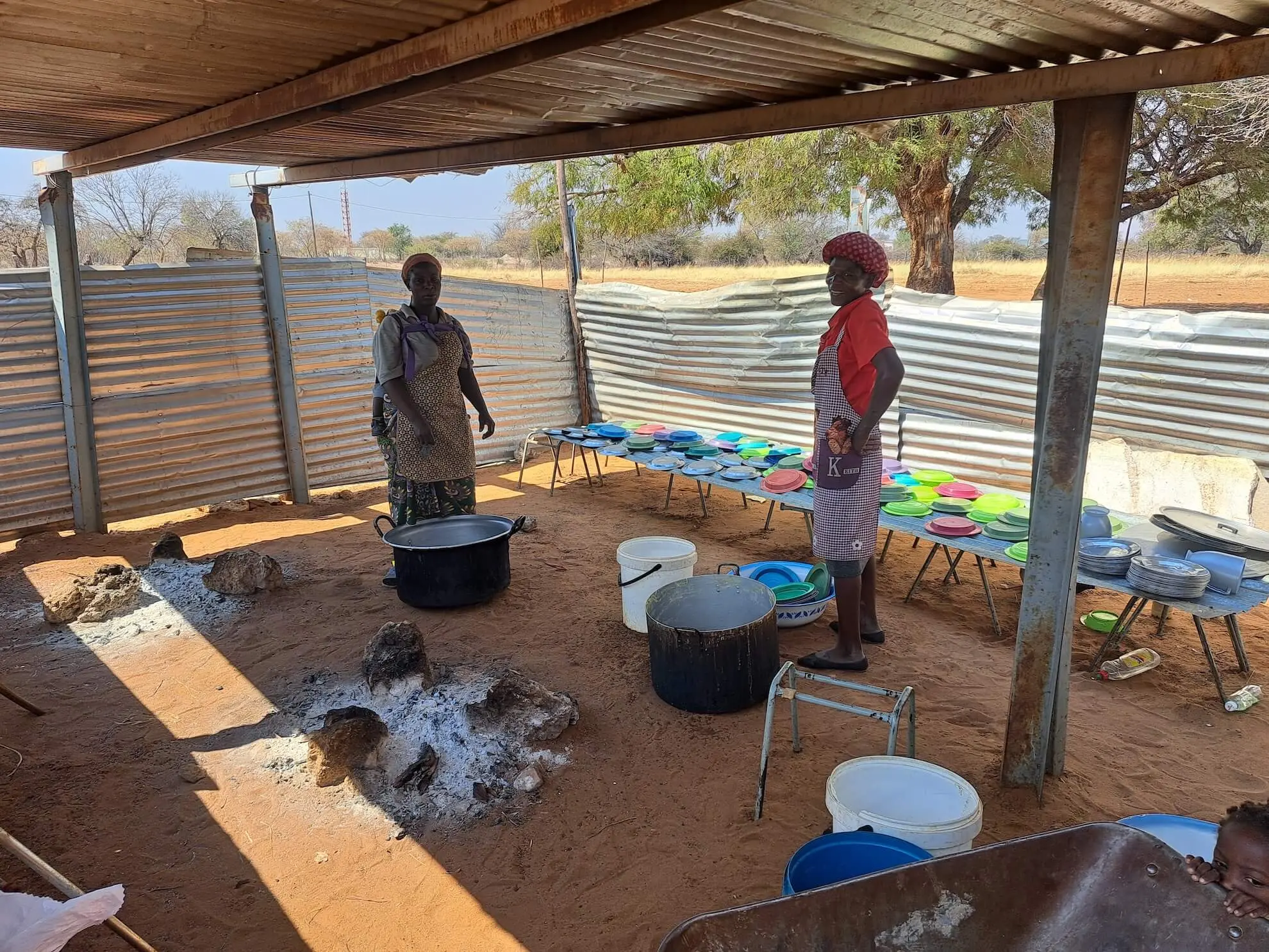 Zwei Erwachsene bei der Ausgabe von Essen für Kinder in Namibia