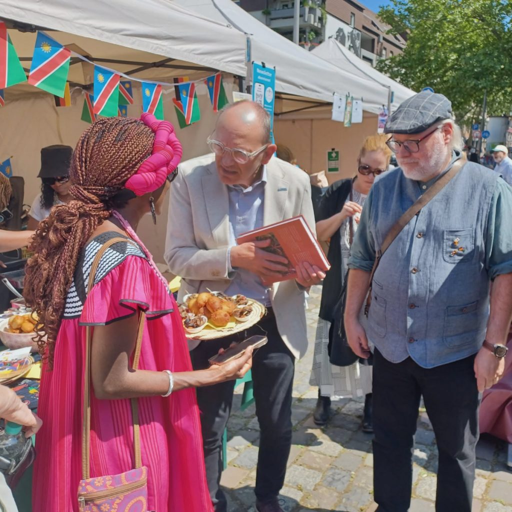 Ester Laub, Vereinsvorsitzende von Kwafa Namibia e. V., mit Mannheims Oberbürgermeister Christian Specht und Wilfried Rosendahl, Generaldirektor der Reiss-Engelhorn-Museen, bei der Tafel der Nationen in Mannheim.